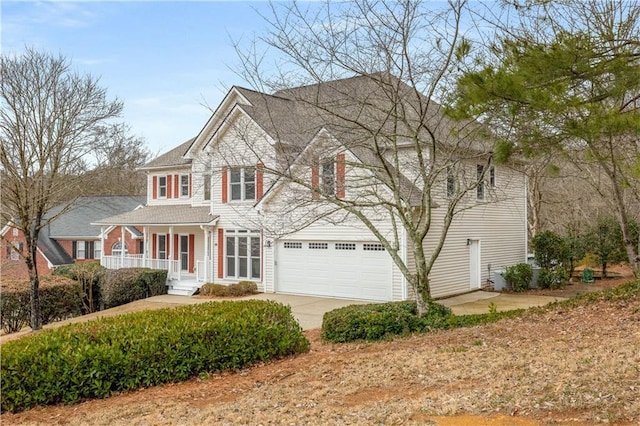 view of front facade with a garage, concrete driveway, and a porch