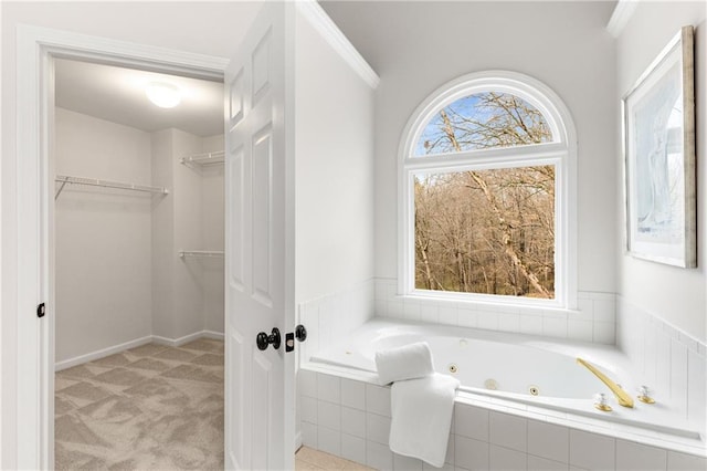 full bathroom featuring ornamental molding, a spacious closet, and a tub with jets