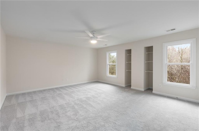 unfurnished bedroom featuring carpet floors, visible vents, baseboards, and a ceiling fan