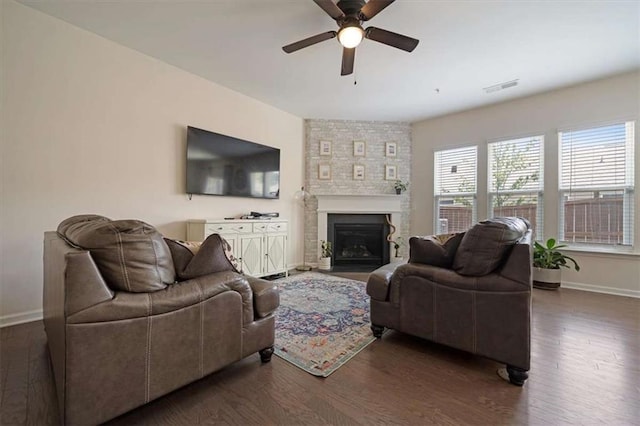 living room with dark hardwood / wood-style flooring, a fireplace, and ceiling fan