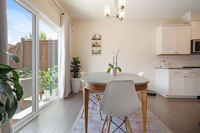 dining area featuring dark hardwood / wood-style flooring and a notable chandelier