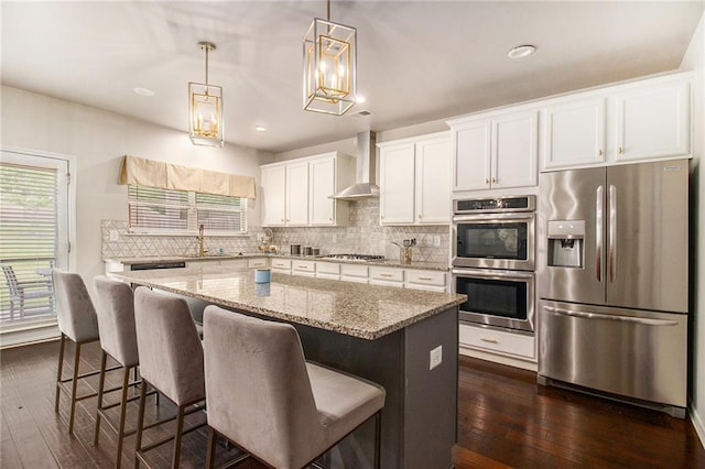 6213 Old Kingston Dr, Atlanta, GA 30331 - kitchen featuring stainless steel appliances, wall chimney exhaust hood, a kitchen island, backsplash, and dark wood-type flooring