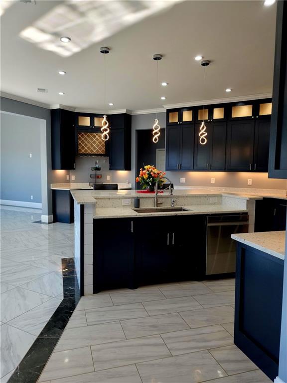 kitchen featuring sink, crown molding, hanging light fixtures, and light tile patterned floors