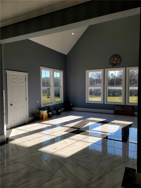 unfurnished living room featuring light tile patterned floors and high vaulted ceiling