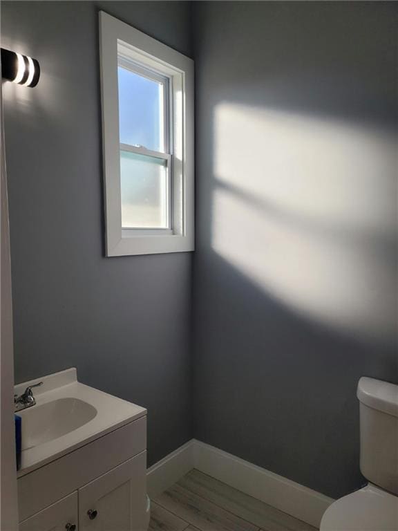 bathroom with hardwood / wood-style floors, vanity, and toilet