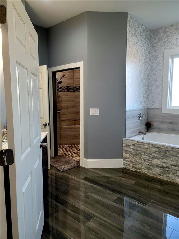 bathroom featuring tiled bath and vanity