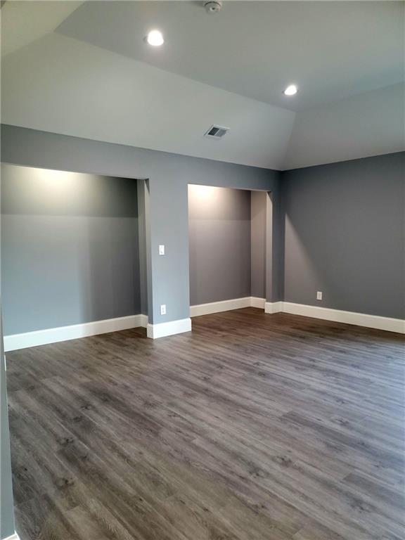 unfurnished room with dark hardwood / wood-style flooring and vaulted ceiling