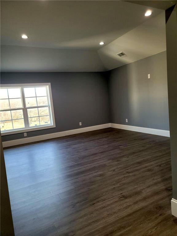 unfurnished room with vaulted ceiling and dark hardwood / wood-style floors