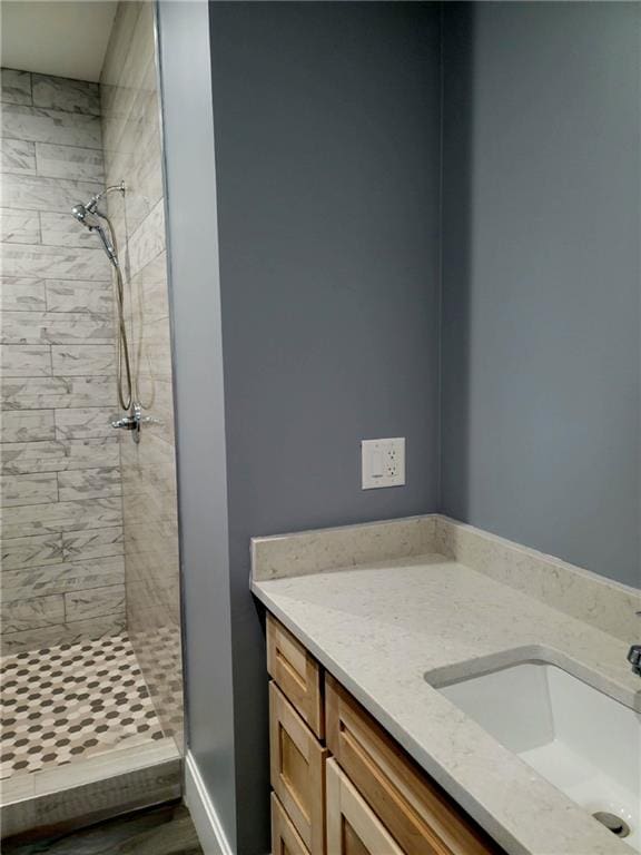 bathroom featuring vanity and tiled shower