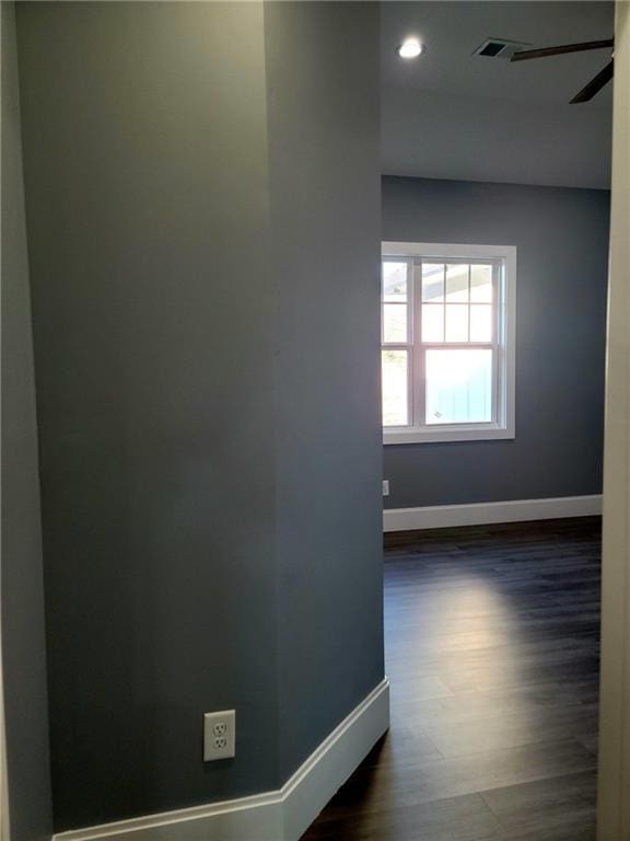 corridor with hardwood / wood-style flooring