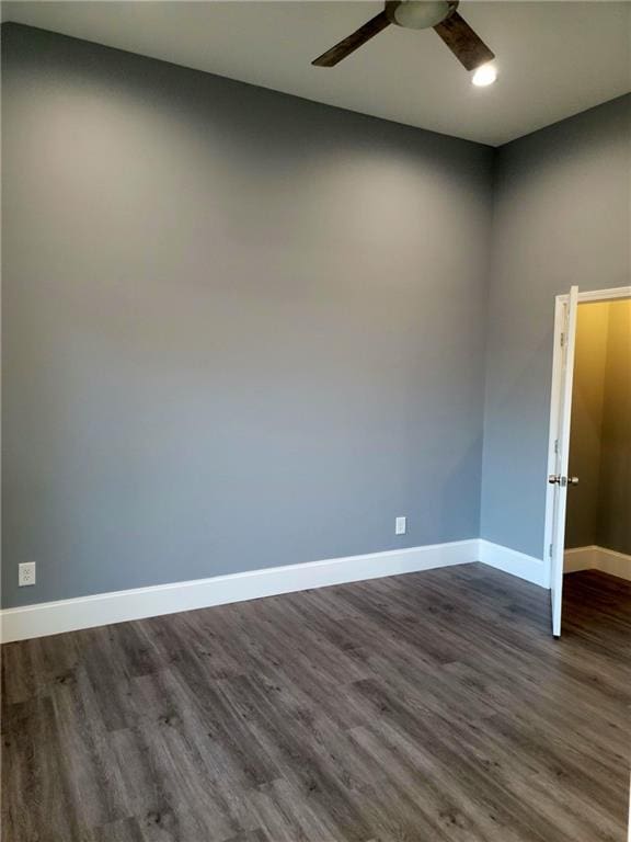 empty room with dark hardwood / wood-style floors and ceiling fan