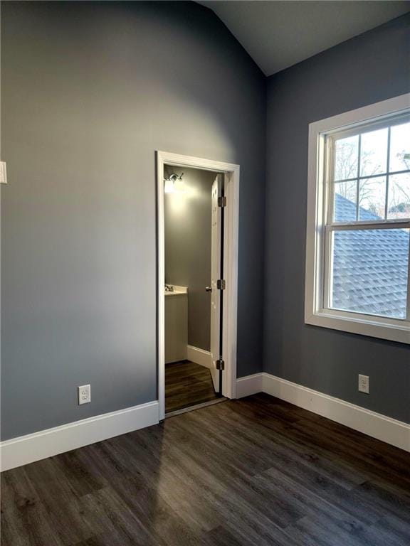 unfurnished bedroom featuring dark hardwood / wood-style flooring and lofted ceiling