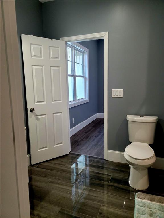 bathroom with toilet and hardwood / wood-style floors