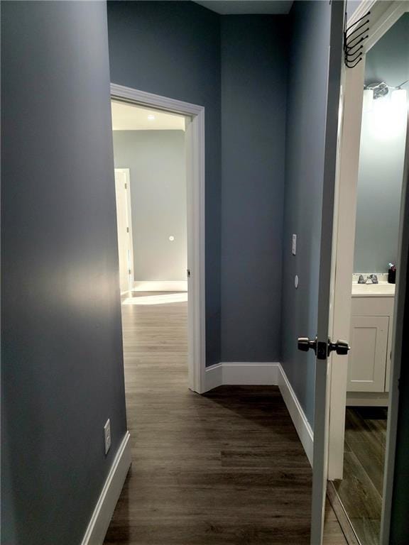 hall with hardwood / wood-style floors and sink