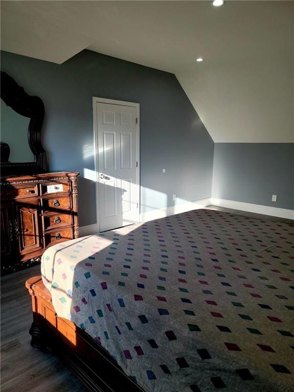 bedroom featuring dark wood-type flooring and vaulted ceiling