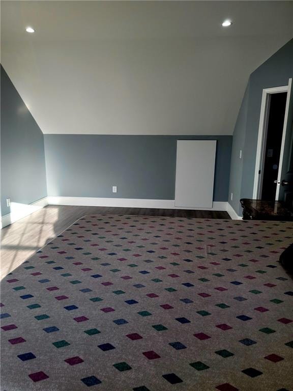 additional living space featuring carpet and lofted ceiling