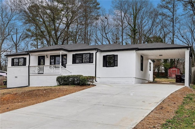 view of front of house with a shed, a carport, and a porch