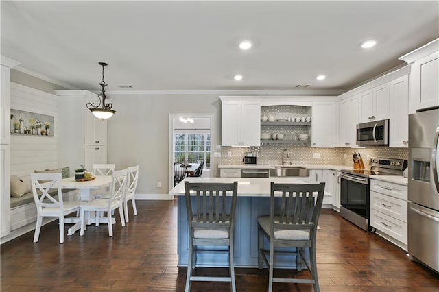 kitchen with a sink, white cabinets, appliances with stainless steel finishes, decorative backsplash, and open shelves