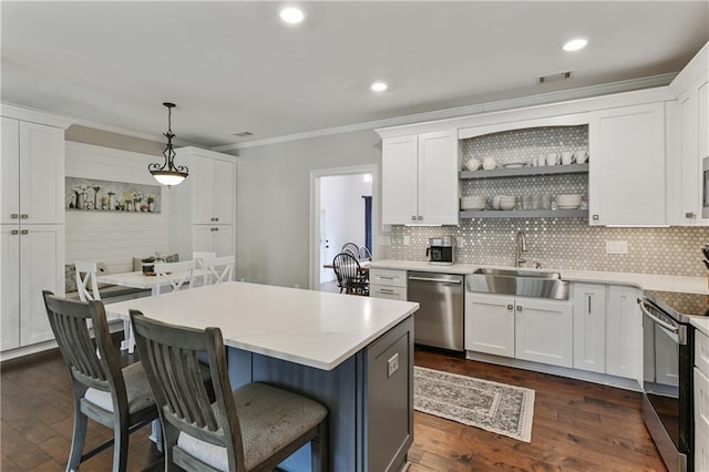 kitchen with appliances with stainless steel finishes, a sink, visible vents, and white cabinetry