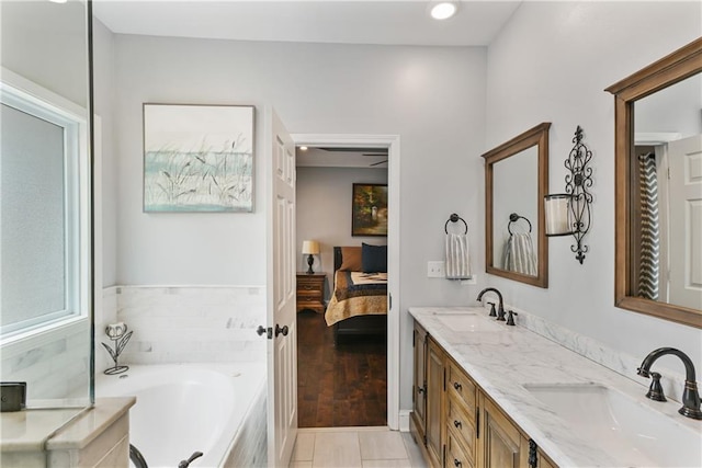 ensuite bathroom with double vanity, ensuite bath, a sink, and a bath