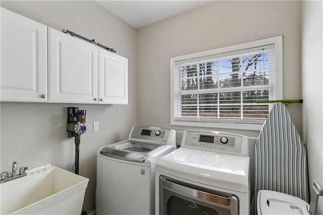 washroom featuring separate washer and dryer, a sink, and cabinet space