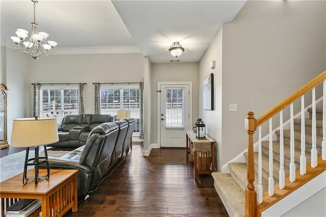 foyer featuring crown molding, wood-type flooring, a chandelier, baseboards, and stairs