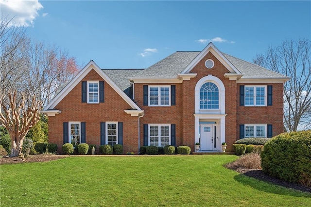 colonial inspired home featuring a front lawn