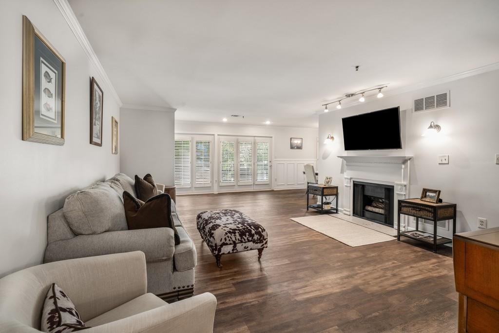 living room with crown molding, dark hardwood / wood-style flooring, and track lighting