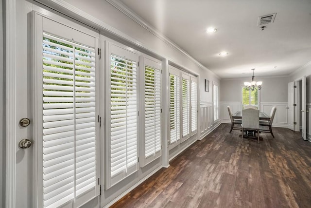 dining area featuring ornamental molding, dark hardwood / wood-style flooring, a wealth of natural light, and a notable chandelier