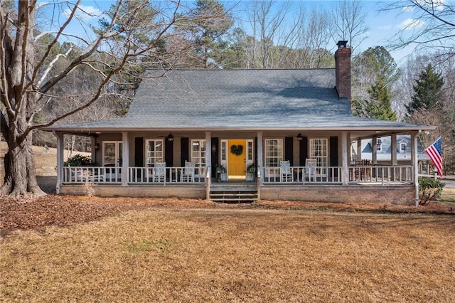 country-style home with a front yard and covered porch