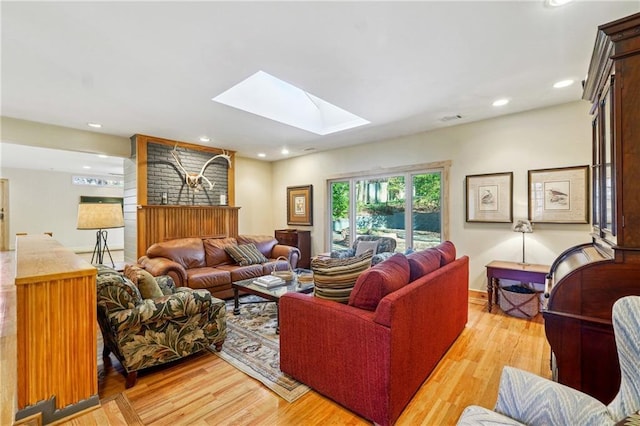 living room featuring recessed lighting, visible vents, light wood-style floors, and a skylight