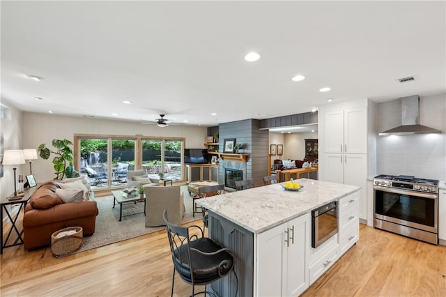 1959 Grand Prix Dr NE, Atlanta, GA 30345 - kitchen featuring stainless steel gas range oven, wall chimney range hood, open floor plan, built in microwave, and white cabinets