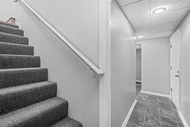 stairs featuring a drop ceiling