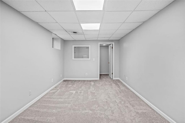 unfurnished room featuring a paneled ceiling and light colored carpet