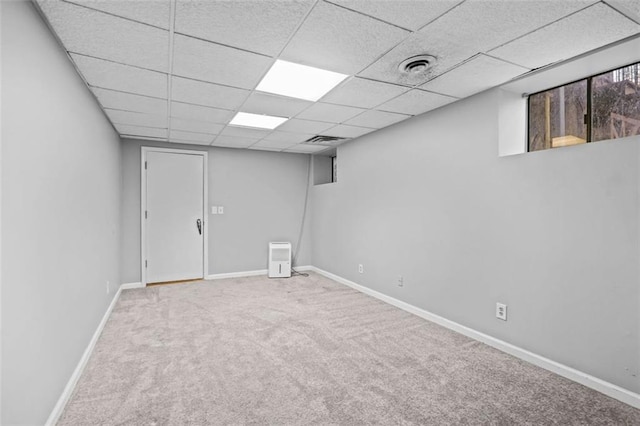 basement with a drop ceiling and carpet