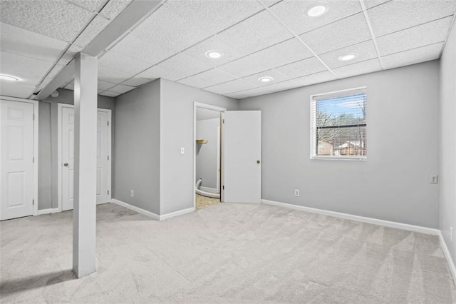 basement featuring light colored carpet and a drop ceiling