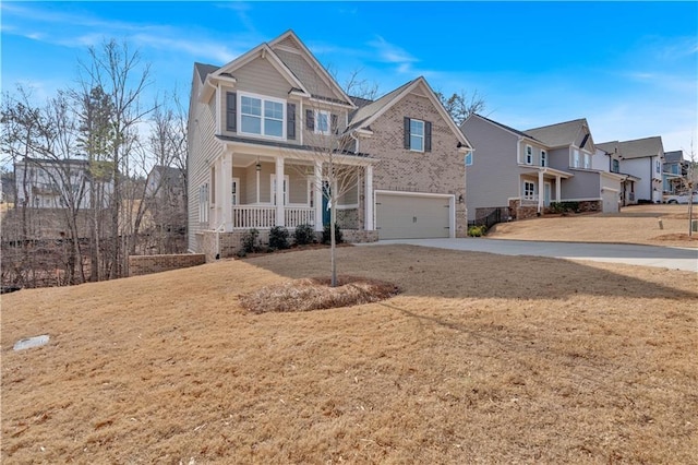 view of front of property featuring a residential view, a front yard, covered porch, driveway, and an attached garage