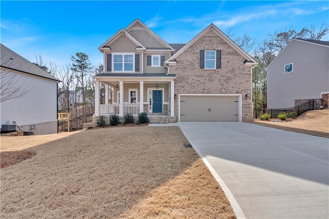 craftsman-style house featuring driveway, a porch, an attached garage, central air condition unit, and brick siding