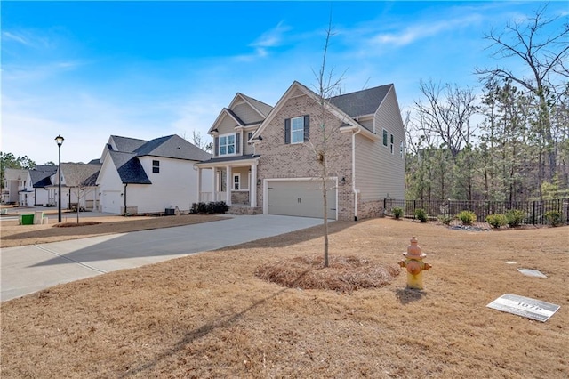 view of front facade with a garage, brick siding, concrete driveway, and fence