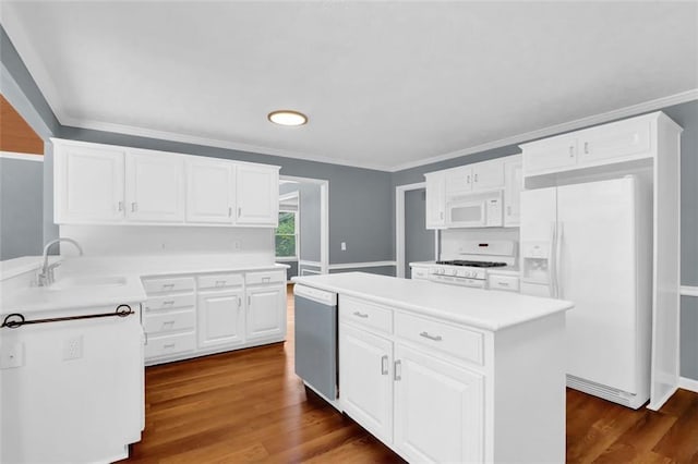 kitchen with dark hardwood / wood-style flooring, ornamental molding, white appliances, sink, and white cabinets