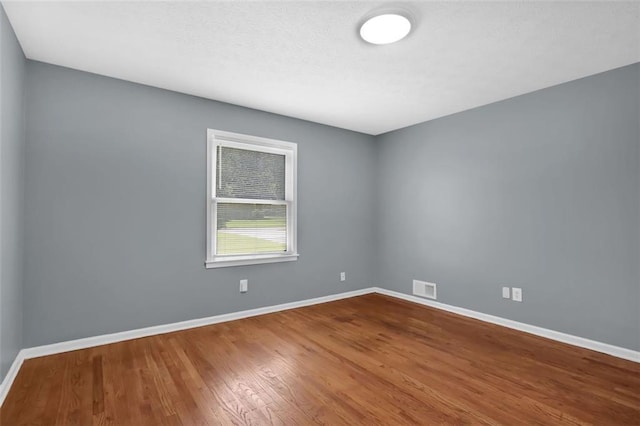 empty room with hardwood / wood-style flooring