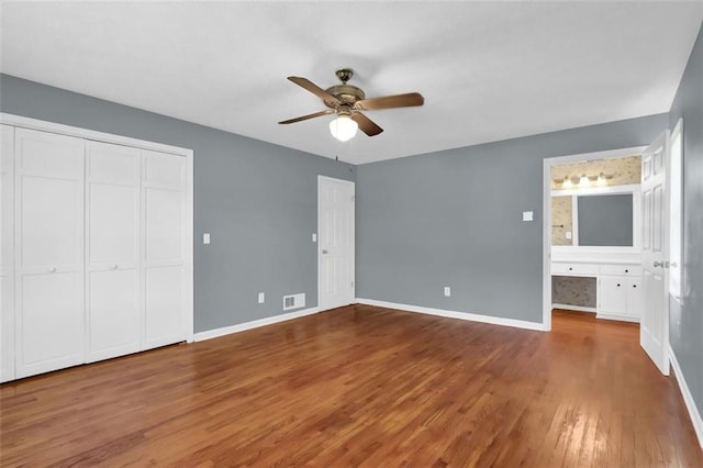 unfurnished bedroom featuring a closet, ceiling fan, hardwood / wood-style floors, and ensuite bathroom