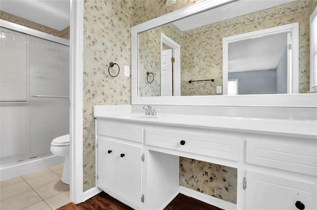 bathroom with toilet, vanity, tile patterned floors, and walk in shower