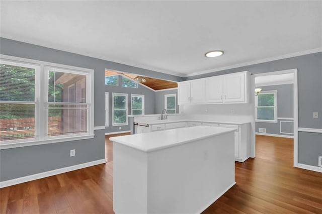 kitchen featuring kitchen peninsula, white cabinets, a wealth of natural light, and dark hardwood / wood-style floors