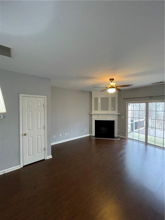 unfurnished living room with dark hardwood / wood-style floors and ceiling fan