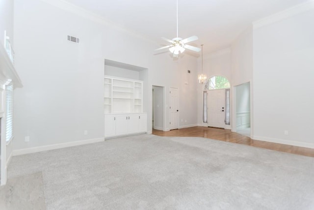 1122 Cayuga Ct, Dacula, GA 30019 - unfurnished living room with light carpet, crown molding, a towering ceiling, a chandelier, and ceiling fan