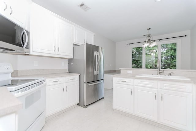 1122 Cayuga Ct, Dacula, GA 30019 - kitchen featuring appliances with stainless steel finishes, light countertops, white cabinets, and pendant lighting