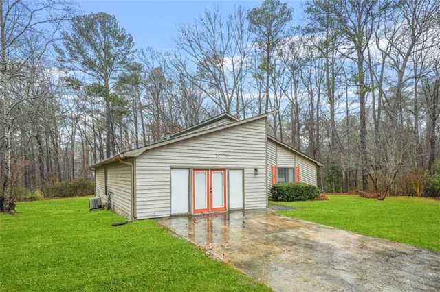 view of outdoor structure featuring french doors, a yard, and central AC unit