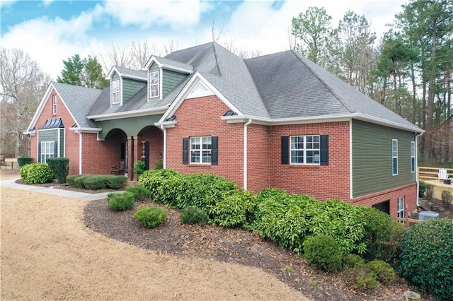 view of front of house with brick siding and roof with shingles