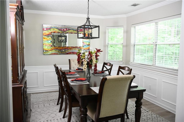 9130 Charlton Pl, Douglasville, GA 30135 - dining room with a decorative wall, wood finished floors, crown molding, and wainscoting